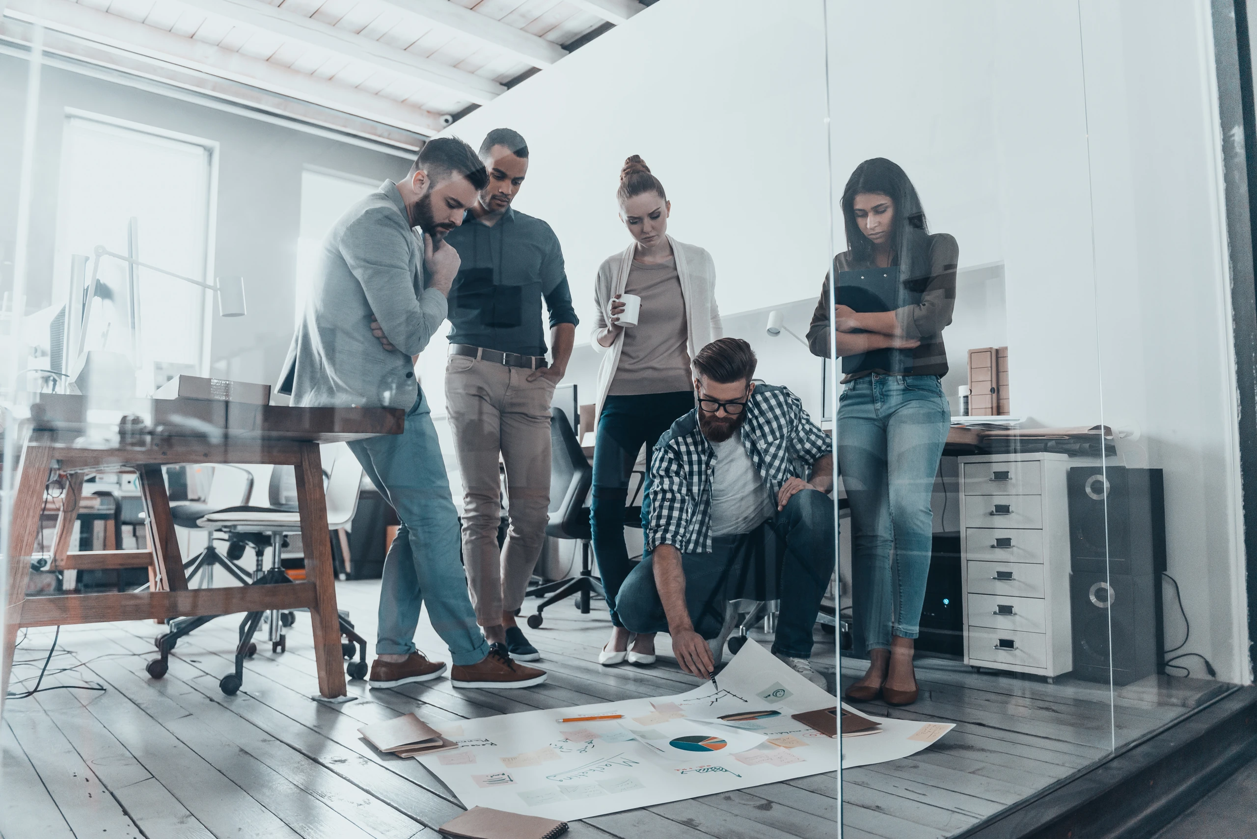 A group of coworkers in an office looking at graphs and statistics.