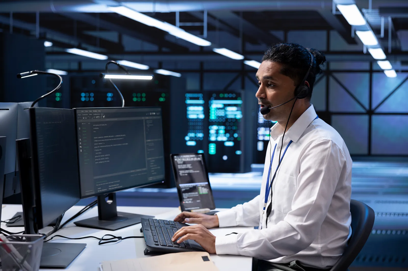 A man sitting at his computer with servers around him.