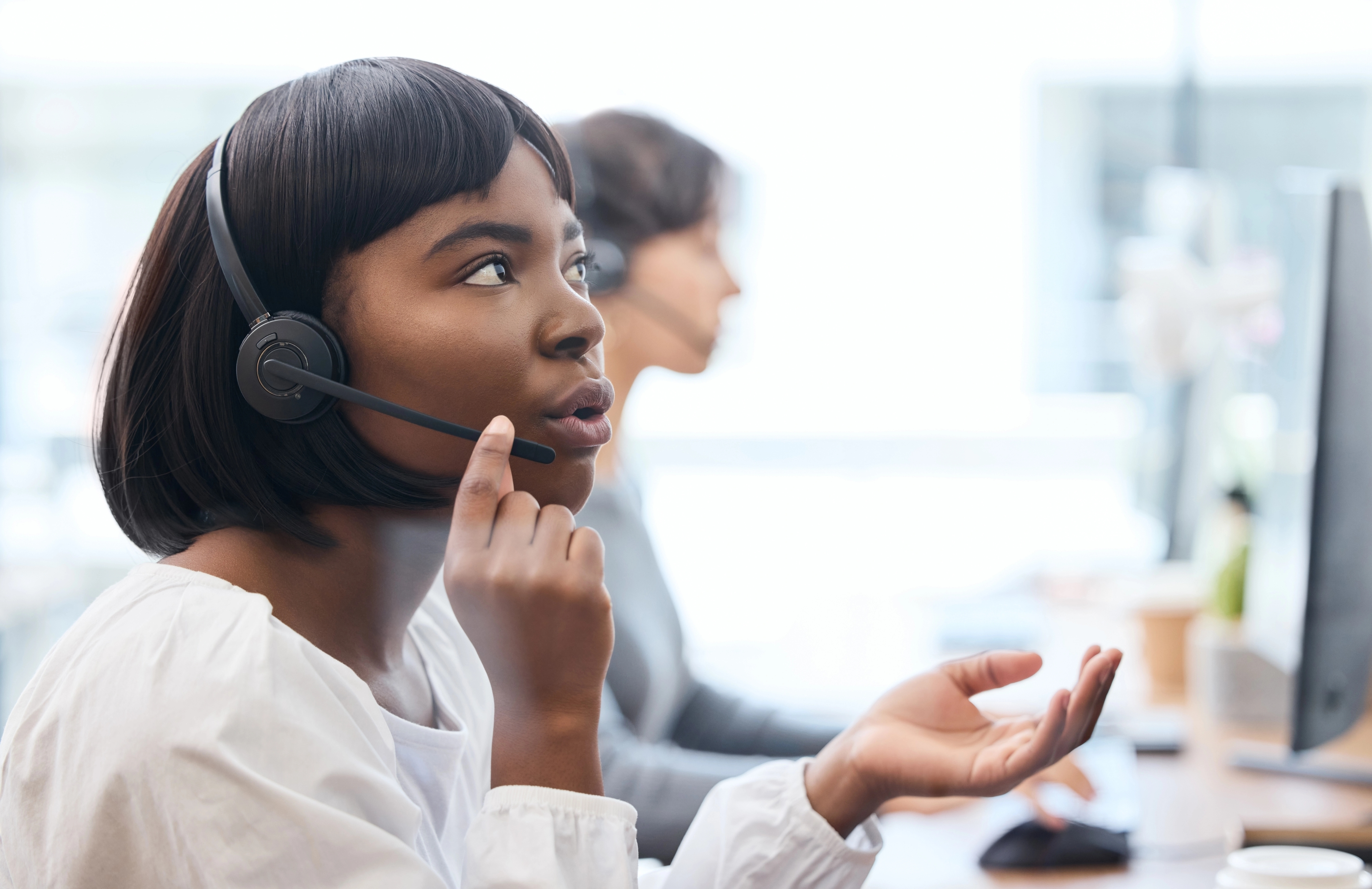 A woman with a headset holding the microphone. It looks like she is explaining something to the pereson on the other end.